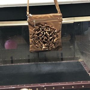 A dark gold bag with a rose design